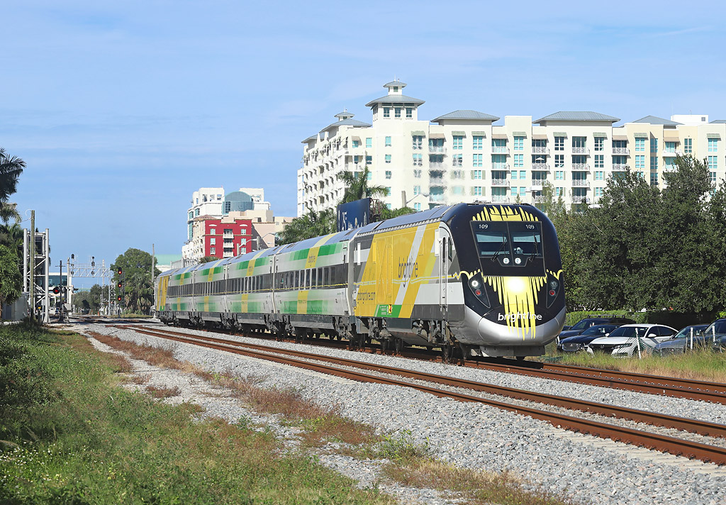 Brightline train Bright Green departs West Palm Beach with the 1400 to Miami, 29 Nov 2018.

The Siemens Charger locomotives either end are 109 & 102.

Brightline are soon to be rebranded as Virgin Trains America...