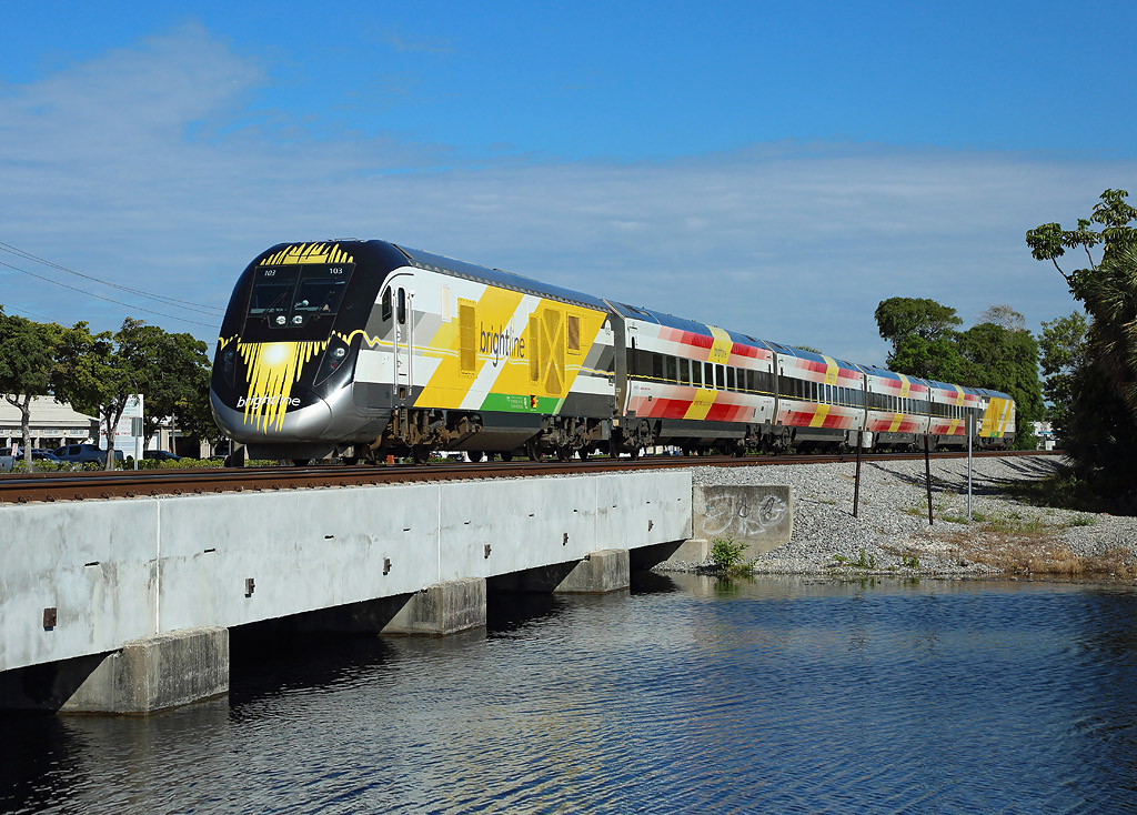 Brightline's Red crosses Cypress Creek whilst working the 0930 West Palm Beach - Miami, 27 Feb 2019.

103 is the front Charger locomotive...