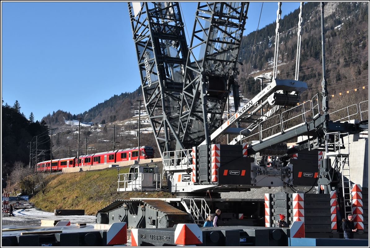 Brückenbaustelle Neue RhB-Hinterrheinbrücke bei Reichenau-Tamins. Ein riesiger Liebherr Kran wurde montiert, um die neue Brückenteile zu positionieren. IR 1140 mit ABe 8/12. (25.12.2017)