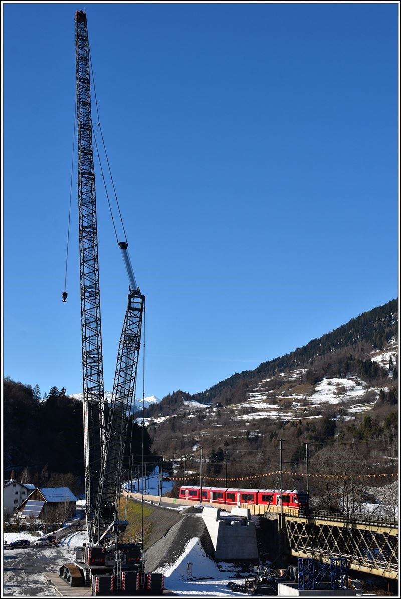Brückenbaustelle Neue RhB-Hinterrheinbrücke bei Reichenau-Tamins. Ein riesiger Liebherr Kran wurde montiert, um die neue Brückenteile zu positionieren. S1 1519 mit Allegra ABe 4/16 3104 auf dem Weg nach Rhäzüns. (25.12.2017)