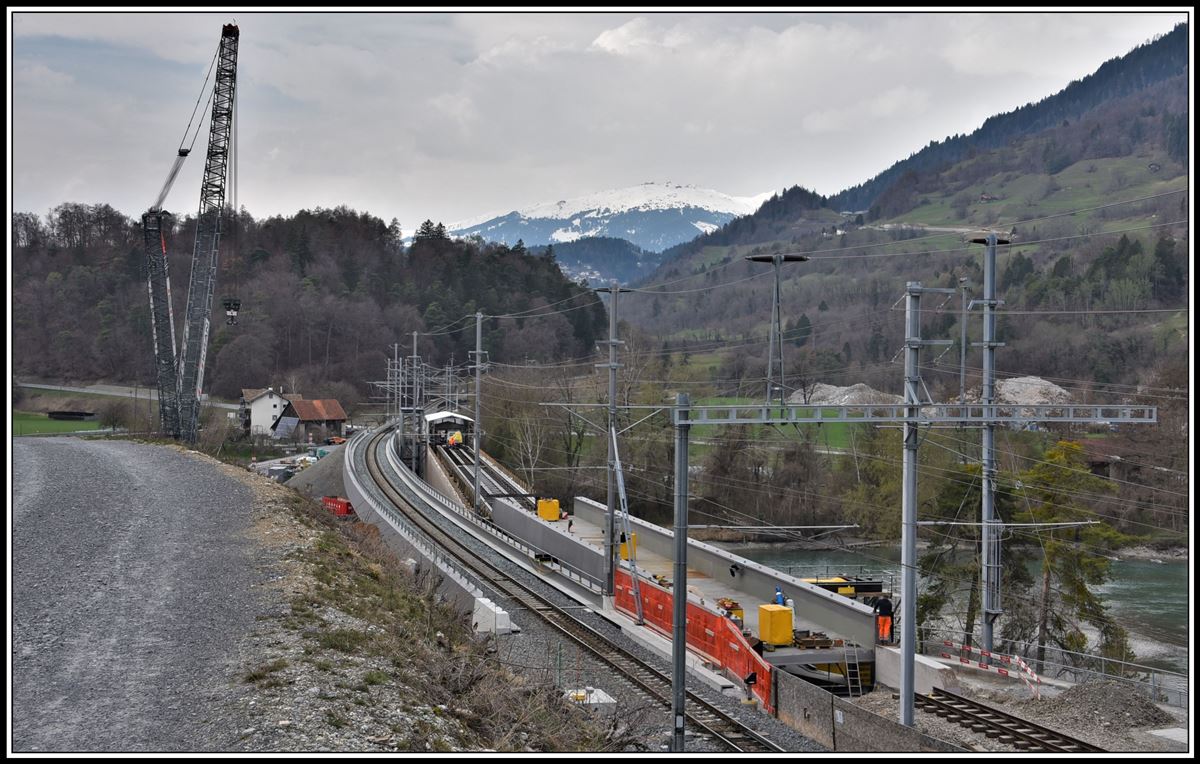 Brückenbaustelle in Reichenau-Tamins. Nachdem die neue Hinterrheinbrücke links in Betrieb genommen wurde, wird die alte Brücke saniert. Das neue Brückenteil im Vordergrund wurde mit dem Kran auf die alte Brücke gehoben und anschliessend an seine Position über der Nationalstrasse geschoben. Sie muss jetzt noch abgesenkt werden. (02.04.2019)