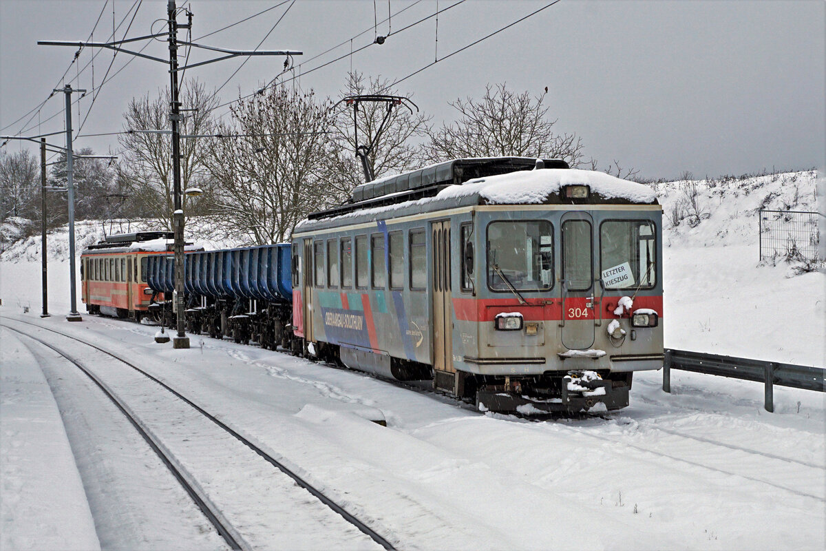 BTI KIESZUG LETZTE FAHRT.
Die seit dem September 2003 geführten Kiestransporte zwischen der Grube Siselen-Finsterhennen und dem Hurni Kies- und Betonwerk AG in Sutz wurden am 10. Dezember 2021 eingestellt. Während dieser Zeit wurden über zwei Millionen Tonnen Kies und Aushubmaterial per Bahn befördert. Der letzte Kieszug wurde bei starken Schneefällen mit dem Be 4/4 302 und dem Be 4/4 304, beide ehemals SNB, geführt. Die vierachsigen „Einseitenkastenkipper“ wurden in der ehemaligen DDR beschafft.
Foto: Walter Ruetsch