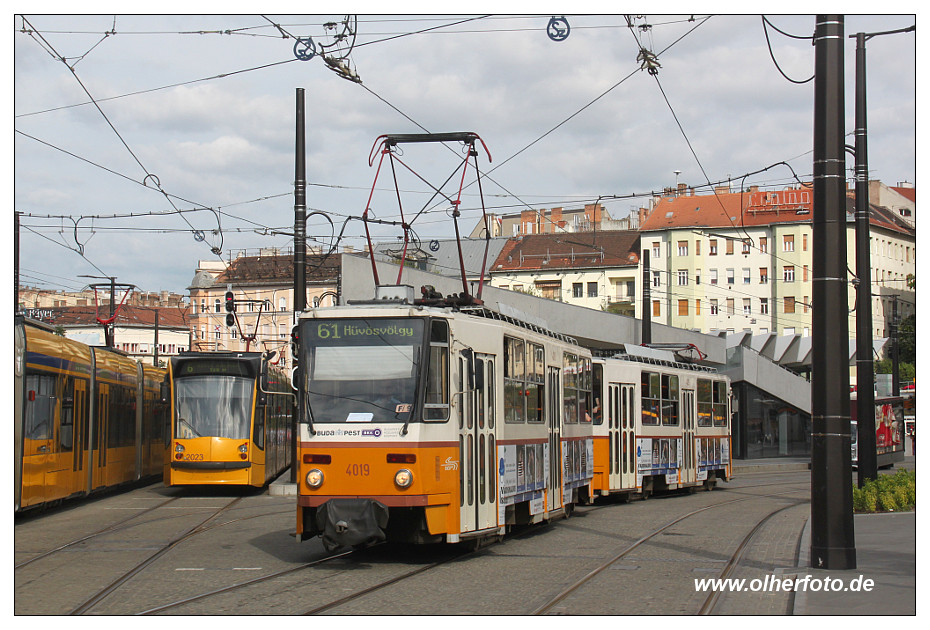 Budapest - Tatra T5C5-Zug mit Tw Nr. 4019 hat soeben die Haltestelle am Széll Kálmán tér auf dem Weg nach Hűvösvölgy verlassen. Links die Combino-Abstellanlage der Linien 4 und 6, zu erkennen Combino Nr. 2023. - 15.07.2016
