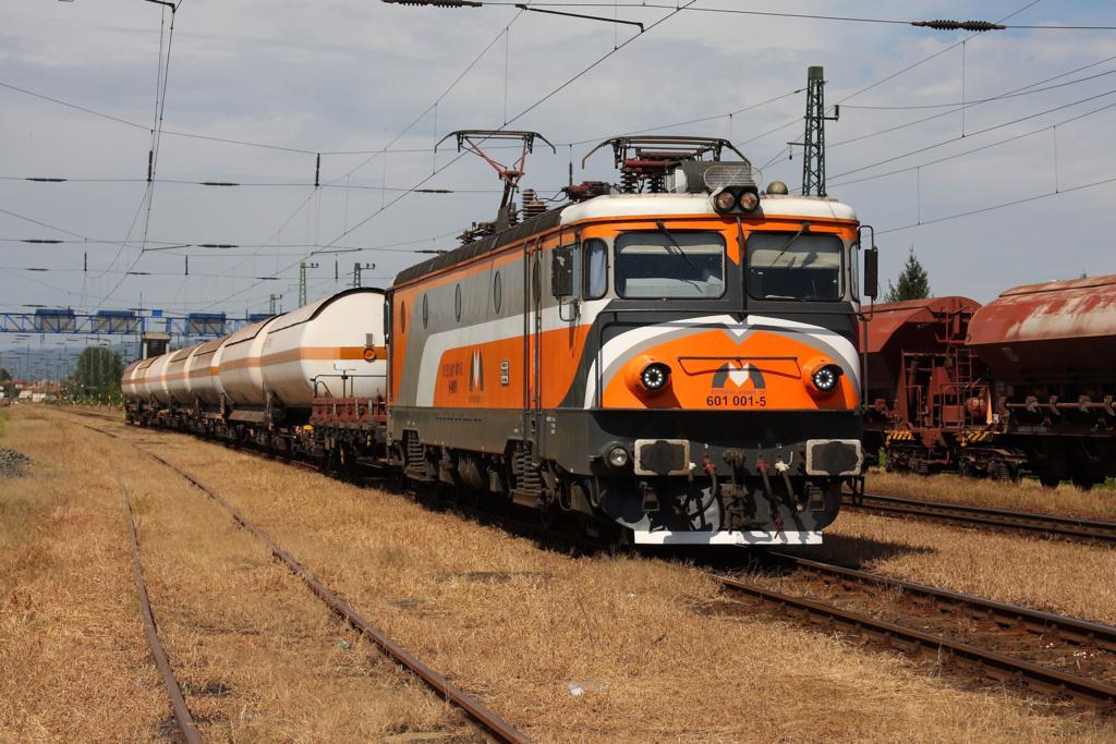 Bunt aufgepeppt steht 601001 der MMV (Magyar Magar Vasut) vor einem Kesselwagen
Zug im Bahnhof Rakamaz und wartet am 29.8.2012 auf Weiterfahrt in Richtung
Nyireghaza in Südostungarn. Bei der Lok handelt es sich um eine sechsachsige ehemals rumänische Elektrolok.
