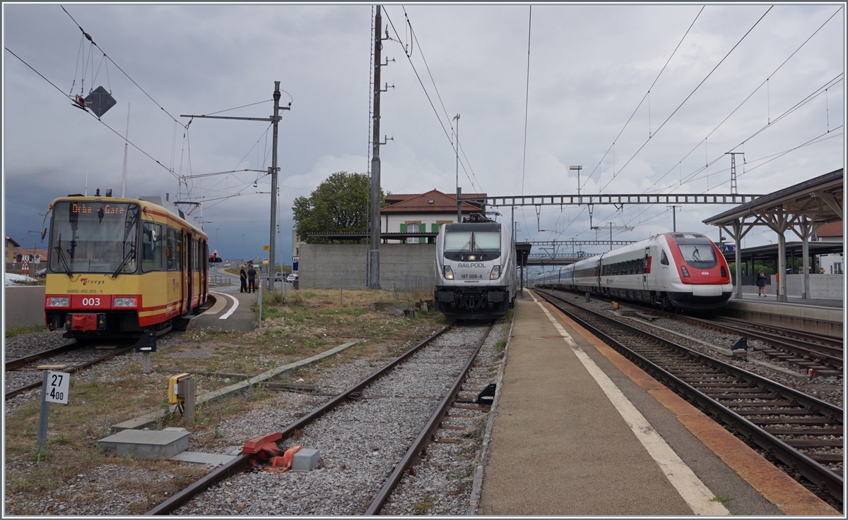 Bunte Bahn in Chavornay: Links wartet der TRAVYS/OC Be 4/8 003 auf die Abfahrt nach Orbe, in der Mitte die an die BLS vermietete RailPool 187 008-8 auf ihre Güterlast und rechts im Bild fährt ein SBB ICN RABDe 500 als IR 5 auf den Weg von Lausanne nach Zürich ohne Halt durch Chavornay. 

15. August 2022