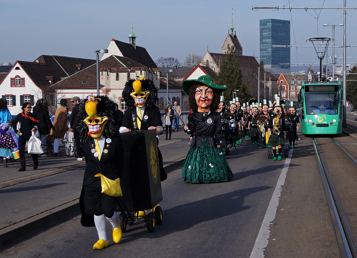 BVB während der BASLER FASNACHT 2014. Obschon während  den drey schenschte Dääg  nicht alle Linien auf den gewohnten Strecken verkehren, kommt es sehr oft zu Begegnungen zwischen Fasnachtscliquen und der BVB. Be 6/8 321 COMBINO (Linie 8) und die  NUGGI SPUGGER  auf der Wettsteinbrücke am 11. März 2014.
Foto: Walter Ruetsch