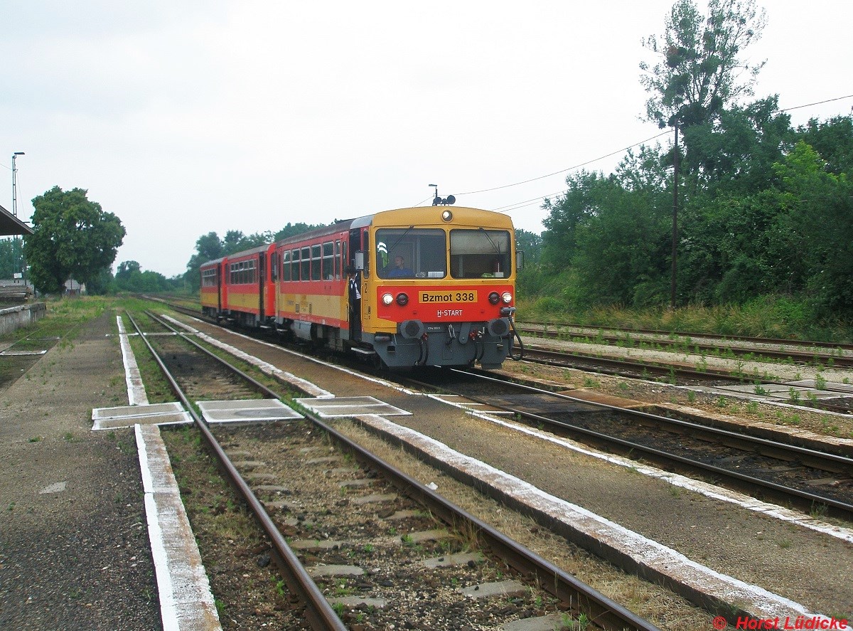 Bzmot 338 trifft am 09.06.2011 mit einem Personenzug von Gyr nach Veszprem in Veszpremvarsany ein. Nach der Stillegung der Strecke von Papa nach Tatabanya ist es in dem ehemaligen Kreuzungsbahnhof recht ruhig geworden.