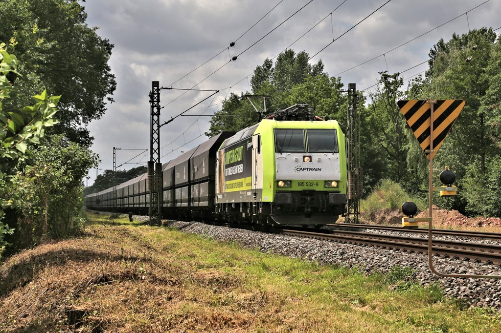 Captrain 185532 hatte am 16.7.2023 den Kokszug am Haken, als der Zug um 12.46 Uhr den Ortsrand von Hasbergen in Richtung Osnabrück fahrend erreichte.