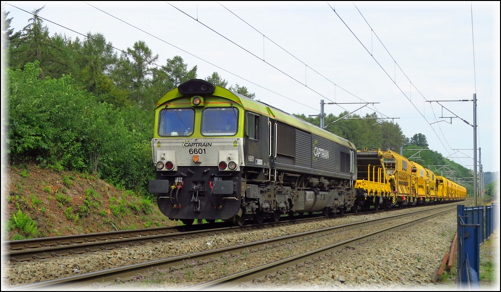 Captrain Class66 samt Gleisbauzug am Haken unterwegs in Richtung Montzen. Hier bildlich festgehalten im Wald bei Moresnet an der Montzenroute, Belgien am 28.08.2019.