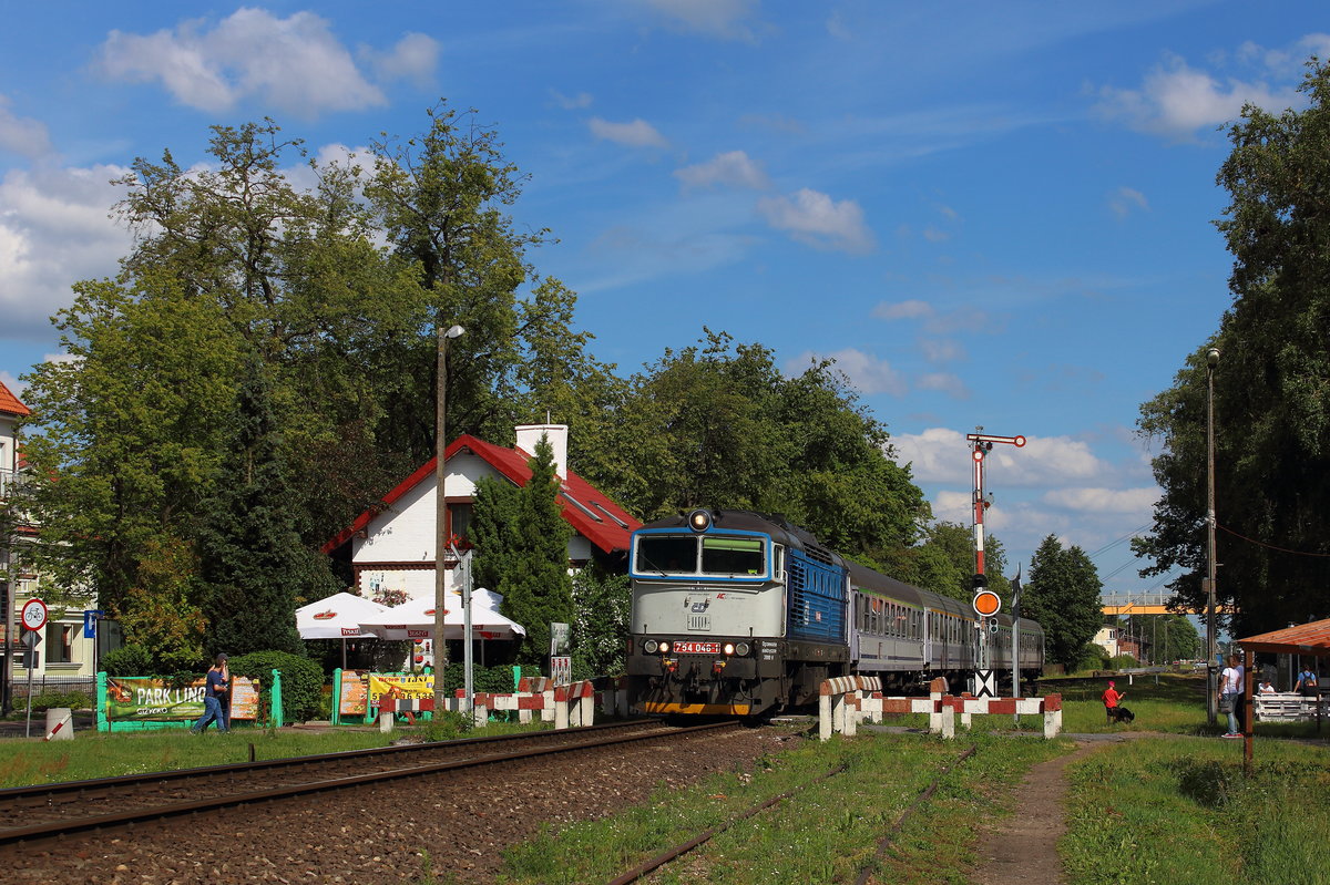 CD 754 046 mit IC TLK 15107  Biebrza  bei ehemaligem Bahnhäuschen mit Bahnübergang für Fussgänger in Gizycko. Aufgenommen am 27.06.2017