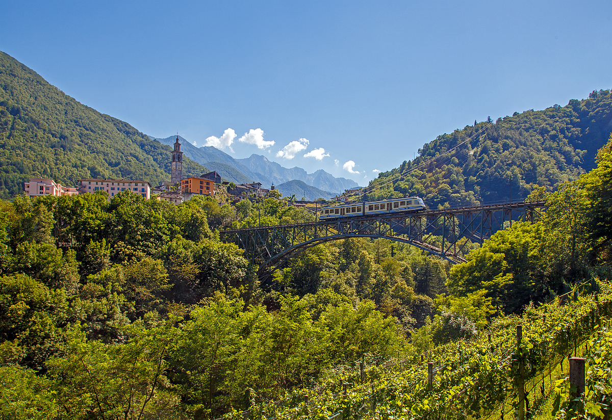 
Centovallibahn - Der FART Gelenk-Triebwagen ABe 4/6 52 überquert am 22.06.2016 die 132 Meter lange Isorno Brücke und erreicht bald Intragna (Tessin). Mit 65 Metern ist der San Gottardo, in Intragna, der höchste Kirchturm im Kanton Tessin.