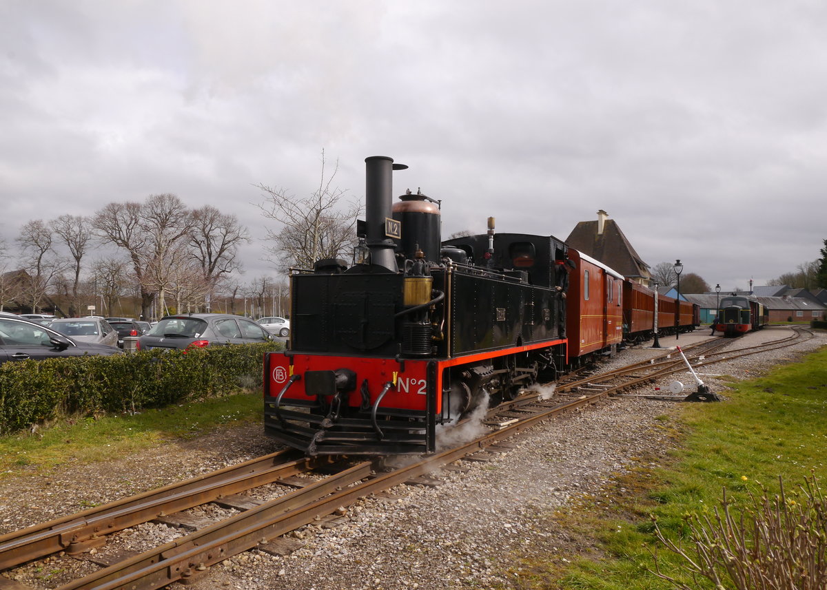 CFBS-Dampflok FCPR-2 fährt mit einem Sonderzug aus dem Bahnhof Saint-Valery-Ville nach Cayeux-sur-Mer.

Diese sehr schön renovierte Dampflok ist eine französisch anmutende Lok mit ungewöhnlichem Kuhfänger. 
Dies hat seinen Grund in einem sehr ungewöhnlichen Loklebenslauf.
Die Meterspurlok mit der Achsfolge 1'C wurde von der französischen Firma Cail 1889 unter der Fabriknummer 2296 gebaut.
Geliefert wurde sie an die erste Panamakanalbaugesellschaft, welche mit französischem Kapital unter der Leitung von Ferdinand de Lesseps versuchte einen Panamakanal zu bauen.
Hier war sie von 1889-1891 im Einsatz, dann war diese erste Panamakanalbaugesellschaft pleite und die Lok wurde nach Puerto Rico verkauft, das damals noch eine spanische Kolonie war.
Die Ferrocarriles-de-Puerto-Rico FCPR errichteten auf der Insel ein Meterspurnetz. Hier erhielt sie die Betriebsnummer 2, die sie auch heute trägt.
Puerto Rico wurde 1898 von den USA annektiert und aus der Bahngesellschaft wurde 1902 die American Railroad of Puerto-Rico (welche schlussendlich bis 1956 existierte). Die Lok erhielt in Folge einige typisch amerikanische Anbauten, wie den Kuhfänger. 1929 wurde die Lok ausgemustert und sie kam als Museumsstück in die USA ins Henry Ford Museum in Dearborn bei Detroit (Michigan). Völlig ungewöhnlich, aber der alte Henry Ford hatte auch ein Faible für Loks.
Nachdem sie hier Jahrzehnte zugebracht hatte wurde die Sammlung des Museums 1977 restrukturiert und die Lok, die mit amerikanischer Geschichte so gar nicht zu tun hatte, wurde vom Museum an eine lokale Bank in der Kleinstadt  
Traverse City (Michigan) verkauft. Diese residierte damals in einem stillgelegten Bahnhof und stellte die Lok davor auf. Nachdem die Bank 1994 in ein neues Gebäude zog und den Bahnhof verkaufte war die Lok übrig. Nun wurde man in Frankreich auf die Lok aufmerksam und die CFBS bemühten sich erfolgreich die Lok zurück über den Atlantik nach Frankreich zu holen. Bei der CFBS wurde die Lok wieder aufgearbeitet und 2003 -nachdem sie 74 Jahre abgestellt gewesen war!-  wieder in Betrieb genommen.
2016-03-26 Saint-Valery-sur-Somme Ville