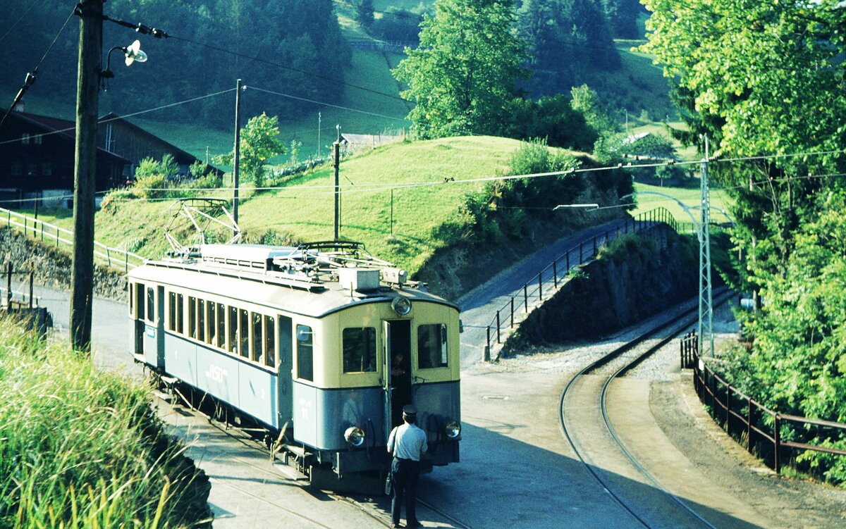 Chemin de fer Aigle–Sépey–Diablerets (ASD)_ Ach, die Fronttür wurde tatsächlich manchmal benutzt ?! __BCFe 4/4 Nr.11 (SWS, AEG; 1913) in Les Planches, an der Streckenverzweigung, rechtes Gleis von/nach Aigle, linkes Gleis von/nach Les Diablerets.Hinter dem Betrachter die Brücke über die Grande Eau mit dem Gleis zum Kehrbhf. Le Sépey.__08-09-1976