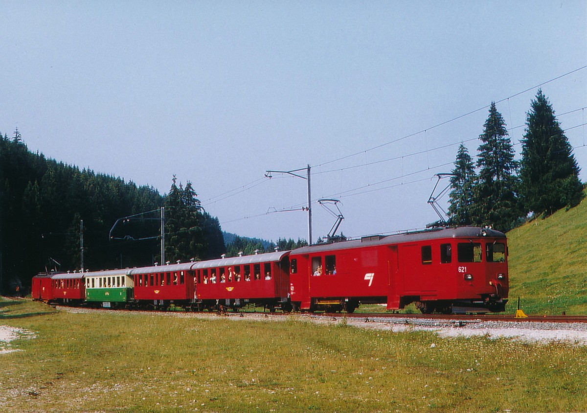 CJ: Das zweite Wochenende im August findet jeweils in Saignelégier (Jura) der traditionelle Marché Concours statt. Da das Festgelände direkt neben dem Bahnhof liegt, reisen die Besucher sowie die geladenen Gäste des jeweiligen Gastkantons mit der Bahn an. Für die Bewältigung des Grossverkehrs gelangt deshalb an diesem Wochenende bei der CJ jedes verfügbare Rad zum Einsatz. Extrazug mit De 4/4 I 401-402, drei B4 (ehemals Brünig), AB 301 (ehemals SZB) und dem BDe 4/4 621 (ehemals BTI/FW) zwisch Glovelier und Saignelégier am 8. August 1993. Mit der Inbetriebnahme der ABe 2/6 631-634 im Jahre 2001 fand diese Eisenbahnromantik ein Ende.
Foto: Walter Ruetsch     