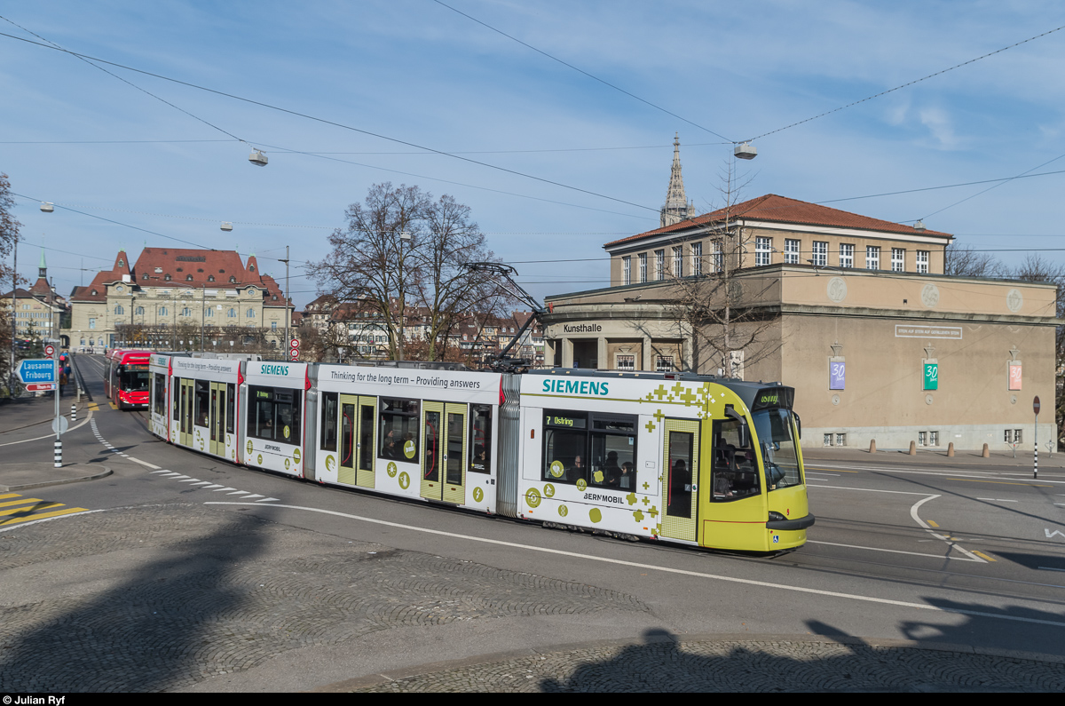 Combino 757 macht bereits seit mehreren Jahren Werbung für Siemens. Am 27. November 2016 konnte das Tram auf der Linie 7 Richtung Ostring beim Helvetiaplatz aufgenommen werden. Die Schatten im Vordergrund gehören zum Welttelegrafendenkmal, welches hier als Fotostandpunkt dient.