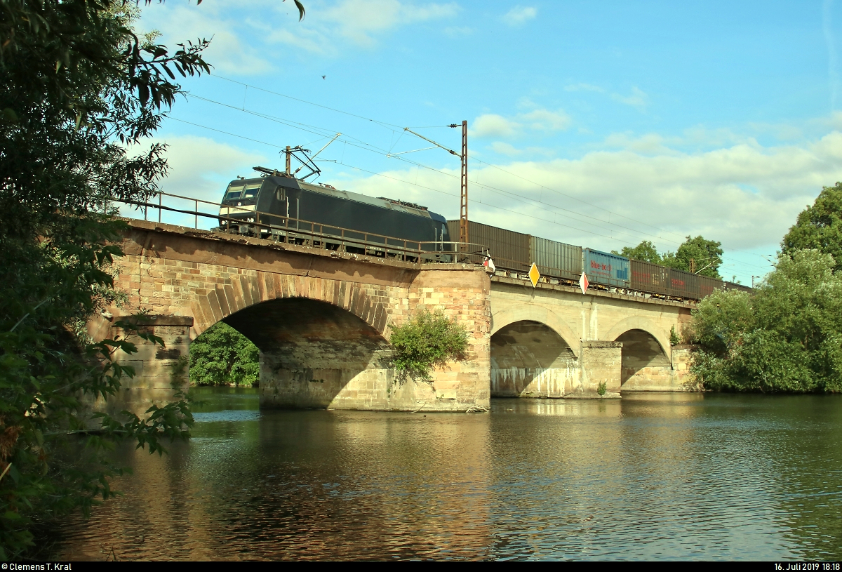 Containerzug (neska Schiffahrts-und Speditionskontor GmbH) mit 185 551-9 MRCE, vermietet an die CFL cargo Deutschland GmbH, überquert die Saale bei Halle-Böllberg/Wörmlitz auf der Bahnstrecke Halle–Hann. Münden (KBS 590) Richtung Angersdorf.
[16.7.2019 | 14:36 Uhr]