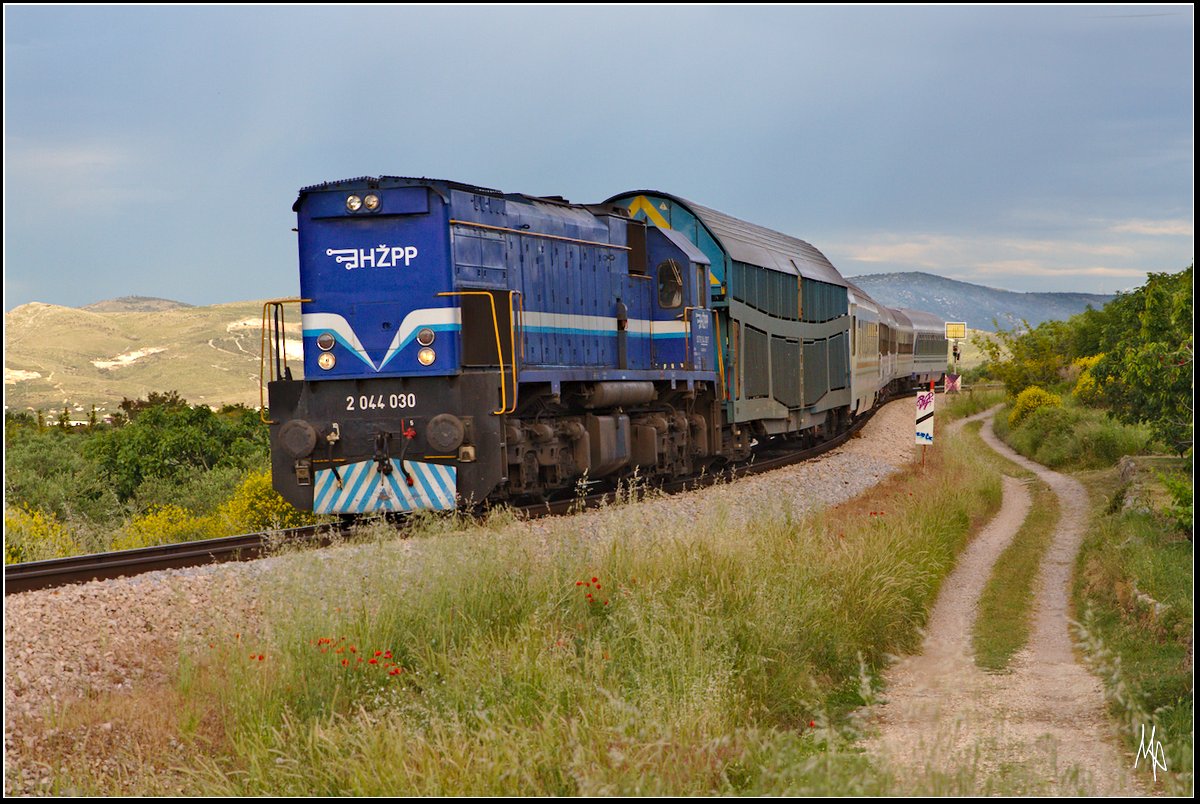D 821, bespannt mit der 2044.030 bei Kastell Stari. Man beachte den Autotransportwagon direkt hinter der Lok. Ebenso interessant ist das alt-österreichische Vorsignal. (18.05.2018)