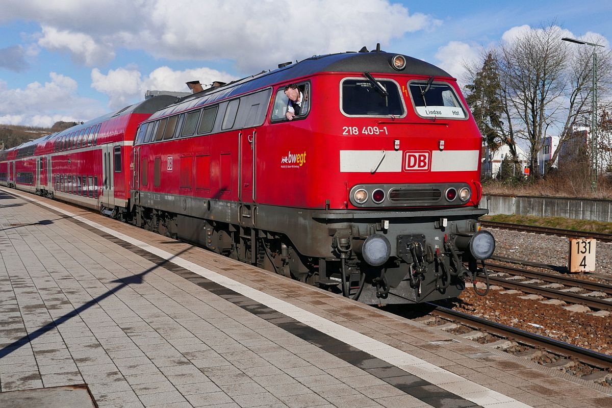 Da hat sich der beim Halt des Zuges herausschauende Lokführer nach dem Losfahren in den Führerstand zurückgezogen, sich aber einige Meter weiter bei dem am Bahnsteigende stehenden Fotografen wieder anders entschieden. 218 409-1 am 29.01.2019 mit den Wagen des RE 4215 von Stuttgart nach Lindau im Bahnhof von Biberach (Riß).
