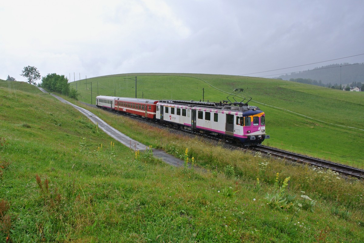 Da der  neue  Schlerzug aus dem Valle de Joux zurzeit bei den TPF in Bulle im Unterhalt ist verkehrt im Moment wieder der alte, ehem. MThB Pendel mit dem ex. RVT Zwischenwagen, les Charbonnires, 02.07.2014.