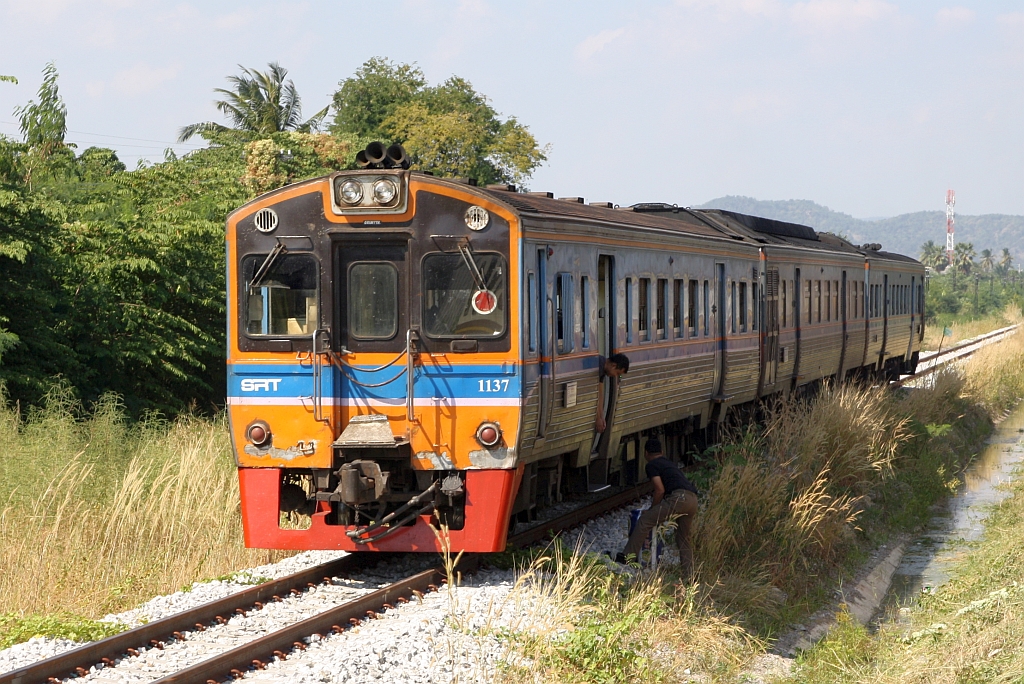 Da im Zuge des 2 gleisigen Ausbau der Southern Line die Anzahl der Gleise in der alten Hua Hin Station auf zwei reduziert wurde verbringt am 09.Dezember 2023 die Garnitur des, nur an Samstag, Sonn- und Feiertag verkehrenden Excursion Train 911/912 (Hua Lamphong - Suan Soan Pradipat - Hua Lamphong) die Wendezeit nun auf dem noch nicht für den Durchgangverkehr frei gegebenen neu errichteten zweitem Streckengleis nördlich der Hua Hin Station. - Im Bild der THN 1137 als Teil dieser Garnitur.