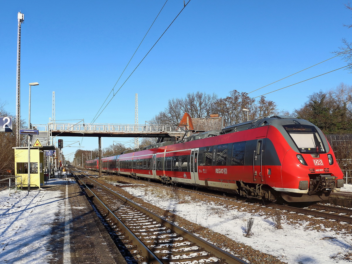 Dabendorf am 21. Januar 2022, Ausfahrt RE 7 in Richtung Berlin mit 442 827 beim Unterfahren der Fußgängerbrücke.