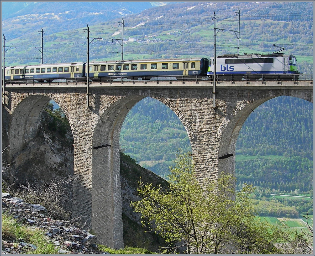 Damals noch zuwenig von den konstruktiven Tipps bei BB.de profitiert, habe ich den Zug nicht vollständig mit aufs Bild genommen. Da mir die Aufnahme mit der damals achtzig Tonnen schweren Lok auf dem zierlichen Lugelkinn Viadukt trotzdem gefällt, habe ich das Bild nun neu bearbeitet und hoffe, dass es beim einen oder anderen auch Gefallen findet.
Die Die BLS Re 4/4 II (ex SBB) fährt mit einem Regionalzug bestehend aus BLS AB und B sowie dem nicht zu sehenden ex SBB Steuerwagen als Regionalzug von Brig nach Goppenstein und erreicht in Kürze Hohtenn.
2. Mai 2006