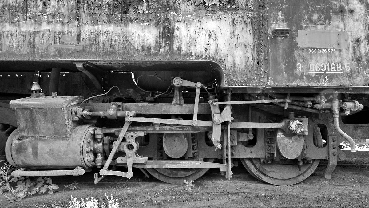 Damfzylinder und Räder an einer ausgedienten Dampflokomotive. (Brohl-Lützing, August 2018)