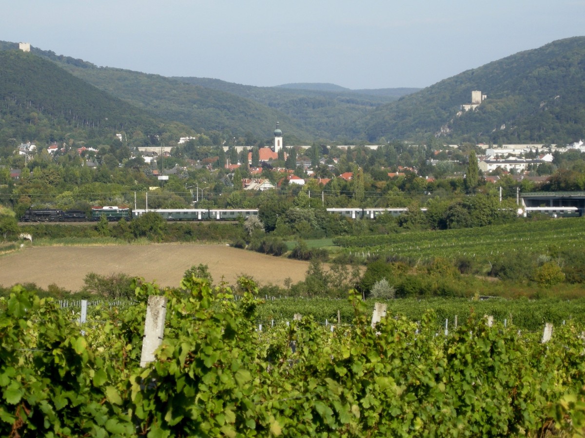 Dampflokomotive 310.23 hat den Bahnhof Baden verlassen und fährt mit einem Sonderzug am 18.September 2011 nach Mürzzuschlag. Im Bildhintergrund der Eingang zum Helenental mit den Burgen Rauheneck und Rauhenstein.