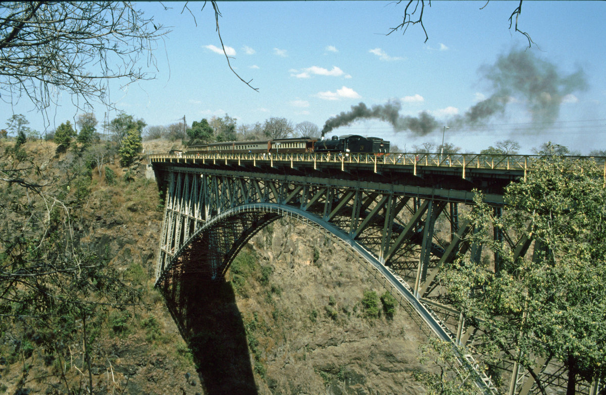 Dampfzug auf der Victoria Falls Bridge.
Aufnahme vom Juli 1997. Soweit ich mich erinnere, war dies ein Dampfzug, der zwischen Bulawayo und Victoria Falls fuhr. Hier ist der Zug auf die Brücke gefahren, um den Passagieren einen guten Ausblick zu gewähren.