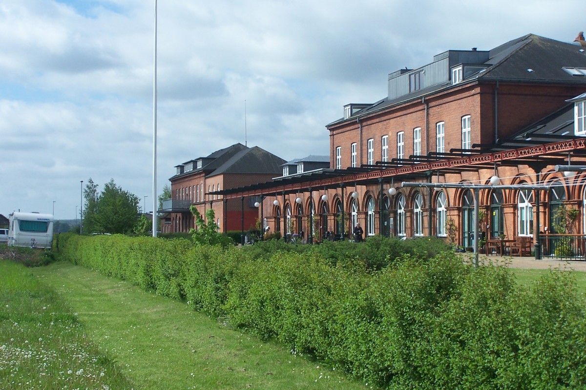 Das alte Bahnhofsgebäude von Nyborg von der ehemaligen Gleisseite aus-man erkennt noch Reste der ehemaligen Bahnsteigüberdachung. Auf dem umfangreichen Gleisareal sind heute Gärten und Wiesen. Aufnahme 23.5.2015.