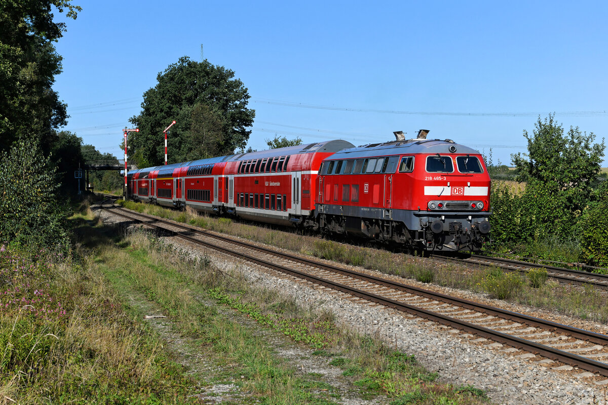 Das Ausfahrsignal des Bahnhofs Thann-Matzbach zeigt Hp1 für die RB 27034 nach München Ost. Am Zugschluss schiebt die 218 465. Zur Zeit des Abschieds von den ECs auf der Allgäubahn war diese Lok von mir gefürchtet, wies sie doch ein sehr ungepflegtes Äußeres auf. Seitdem hat man der Maschine wohl eine Lackauffrischung mit Ceramol gegönnt. Am 12. September 2022 betätigte ich jedenfalls erfreut den Auslöser meiner Nikon, als der Bundesbahn-Klassiker an mir vorbei fuhr. 