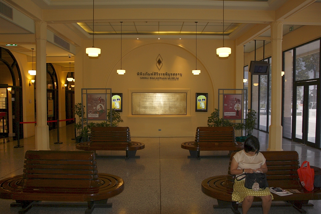 Das Bahnhofsgebäude mit dem markanten Uhrturm der 2003 geschlossenen Thon Buri Station wurde nach Kriegsschäden abgerissen und 1950 im selben Baustil wie 1903 wieder aufgebaut. Heute beherbergt das denkmalgeschützte Gebäude das Siriraj Pimukhsthan Museum. - Im Bild vom 24.März 2024 die Schalterhalle, dort wo sich die einstigen, rechtsseitigen Fahrkartenschalter befanden ist nun eine Informationstafel angebracht.