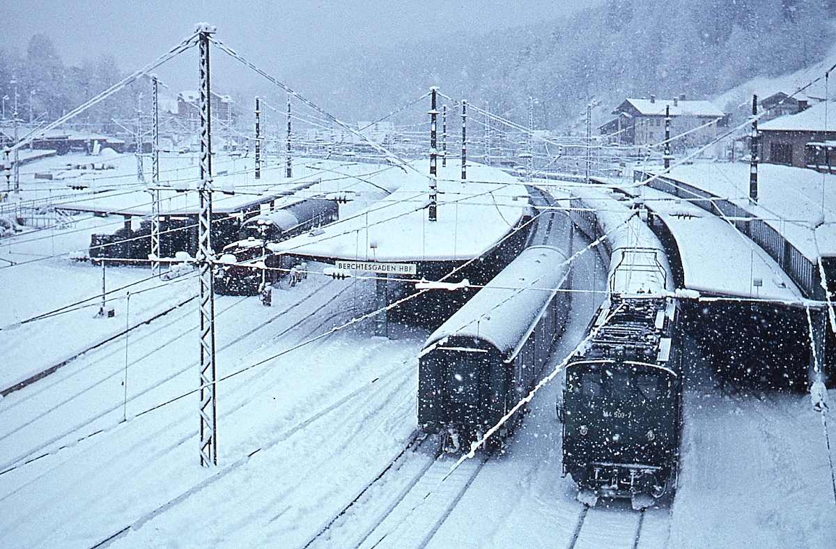 Das Datum (und keinesfalls das Wetter) erinnerte mich heute an den Neujahrsmorgen 1978, als es in den bayerischen Alpen heftig schneite: Im Bahnhof Berchtesgaden steht die 144 509-7 vor einem Nahverkehrszug nach Freilassing. Aus heutiger Sicht nicht selbstverständlich: Der Zug fuhr pünktlich ab und wir erreichten problemlos unseren Anschluss in Freilassing. Mit meinem 6.000sten Bild bei bahnbilder.de wünsche ich Euch allen ein frohes Neues Jahr!