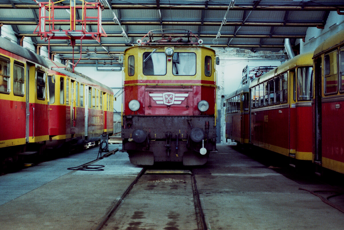 Das Depot Schruns der privaten österreichischen Montafonerbahn war ein Sammelsurium verschiedenster Wagentypen und Lokomotiven. In der Mitte ist evtl. eine Ellok der ÖBB-Baureihe 1045, rechts daneben drei Uerdinger Schienenbusse. 
Datum: 23.04.1984
