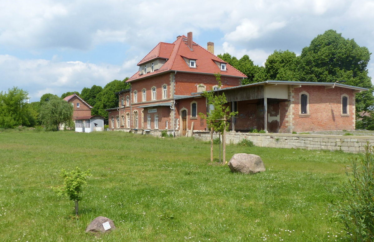 Das ehemalige Bahnhofsgebäude mit der Verladerampe am 21.05.2017 in Laucha (Unstrut). Früher gab es hier statt grüner Wiese noch zahlreiche Gütergleise.