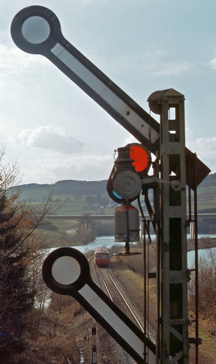 Das Einfahrsignal von Olpe aus Richtung Finnentrop stand unmittelbar vor einer Fußgängerbrücke. 795 235, jetzt beim BW Betzdorf beheimatet (vorher Marburg), hat Einfahrt (3.4.1980). 