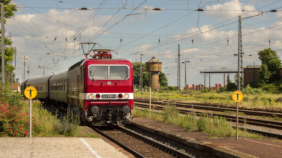 Das Foto verbreitet schon etwas Reichsbahnflair, wenn die beiden, runden Schilder nicht auf dem Bahnsteig stehen würden. Der Sonderzug zum Sachsen-Anhalt-Tag mit DR BR 243 650-9 fährt am 17. Juni 2017 in den Bahnhof der Lutherstadt Eisleben ein. Kurz danach wird die Heimreise nach Jena angetreten. 