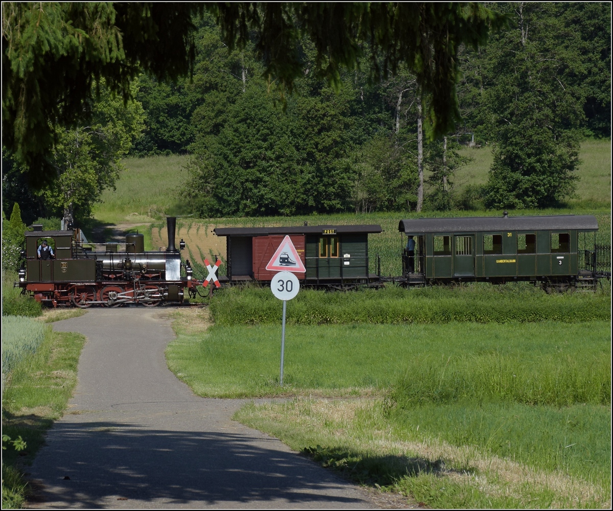Das Kanderli fährt wieder, jeden Sonntag. Wollbach, Juni 2021. Man beachte auch, das unpassende Schild zum Zug auf dem Bahnübergang. Den neuen Lack hat aber die historische Bahn... 