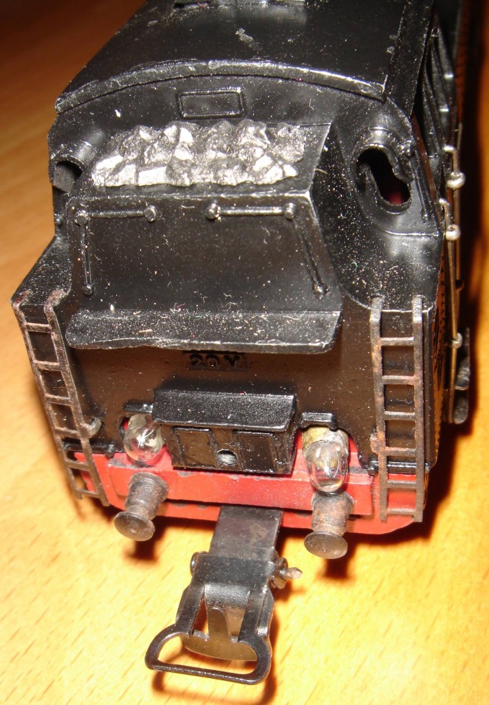 Das ist die Mrklin TP 800.1 von hinten. Man beachte die Lmpchen. Die TP 800 ist eine der wenigen Mrklin Dampfloks, die damals schon auch hinten eine funktionsfhige Beleuchtung vorzuweisen hatten. Auch die Kohle im Kohlenkasten glnzt recht vorbildgetreu. In dieser Ansicht erkennt der Kenner zum ersten mal, dass es sich um die Version 1 handelt. Die Birnchen fr das Spitzenlicht sind von innen durch das Gehuse gesteckt. Bei Version 2 wren sie in einem aus Blech gebogenen Lampenhalter drin, der von auen an das Gehuse geschraubt wird.
Aufnahme 28.09.2014