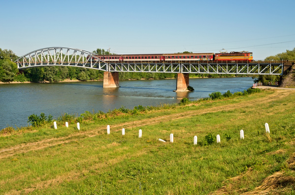 Das Motiv auf der Strecke Nove Zamsky - Komarnò (SK) dürfte die Brücke über die Vah (dt. Waag) knapp vor dem Zielbahnhof Komarnò sein, die Laminatka 240 010 mit ihrem Personenzug am Abend des 4.7.2014 überquert.