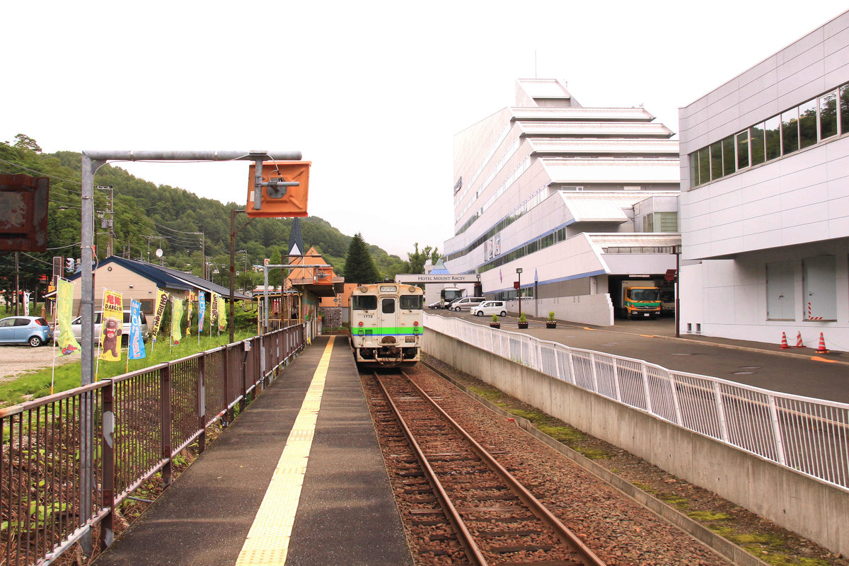 Das nahende Ende des lokalen Verkehrs auf der japanischen Nordinsel Hokkaidô: Das Städtchen Yûbari in Zentral-Hokkaidô war einst ein Zentrum der Kohlenförderung mit deutlich über 100'000 Einwohnern; jetzt sind es nur etwas über 9000. Um den Ort wiederzubeleben baute man in der Hoffnung auf den winterlichen Skitourismus riesige Hotels wie im Bild das  Mount Racey . Doch die Gäste kamen nicht, und jetzt wird die Bahn stillgelegt und eine bessere Anbindung an die Grossstadt Sapporo mittels Fernbussen ins Auge gefasst. Bild: Triebwagen KIHA 40 1772 an der Endstation Yûbari - kaum vorstellbar, dass hier einst endlose Güterzüge und riesige Rangieranlagen zu sehen waren. 1.August 2016. YÛBARI-LINIE