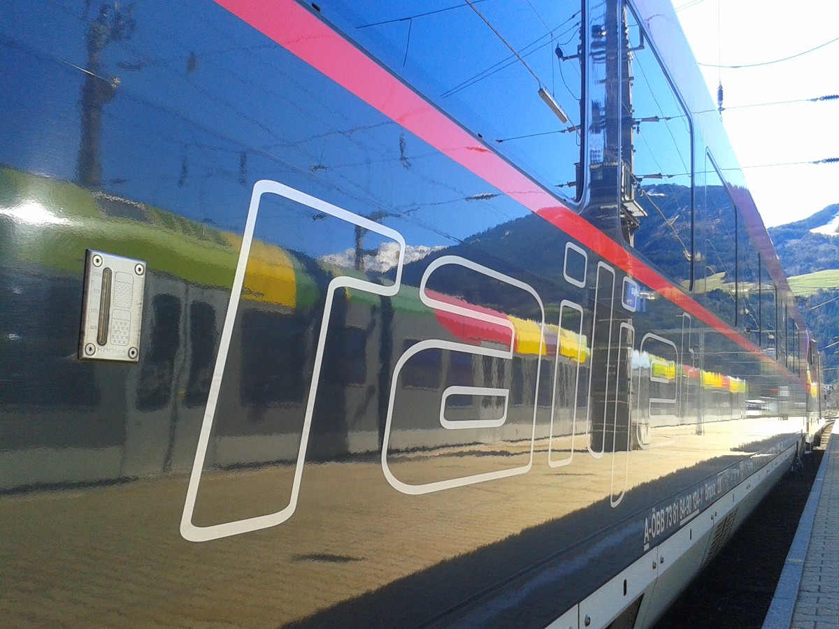 Das railjet Logo (nicht mehr auf den Fenstern) und im Hintergrund das Spiegelbild eines ETR 170 der SAD. (Lienz, 3.4.2015)