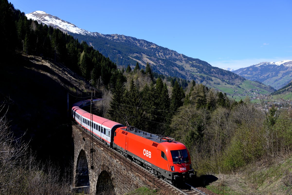 Das Schlossbach-Viadukt zwischen Bad Hofgastein und Anger ist einer der Stellen, an denen sich die Tauernbahn ihren alten Charme behalten hat und sich noch nicht zur zweigleisigen Hochleistungsstrecke gewandelt hat. Entsprechend gemächlich passiert am 22. April 2015 die 1116.143 mit dem EC 113 den Fotostandpunkt, der inzwischen leider schon wieder fast komplett zugewachsen ist.