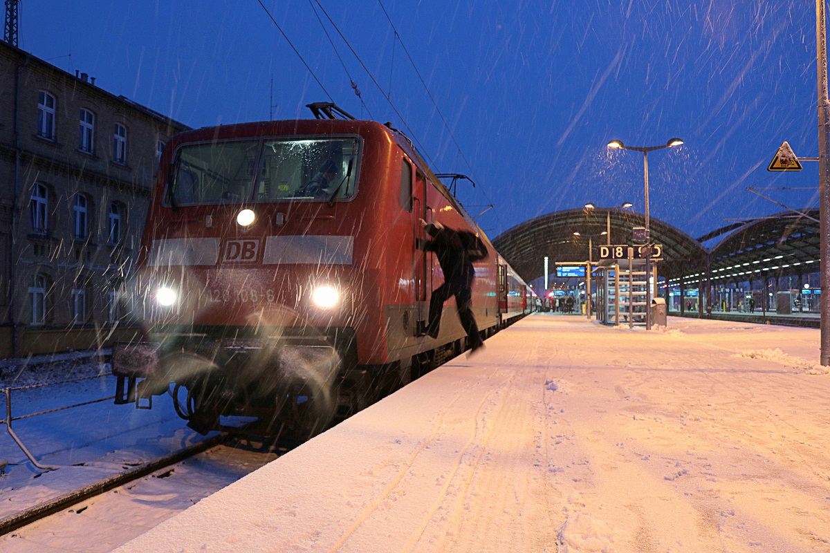 Das vorerst letzte Mal passiert der IC 1969 (Linie 50 MDV) von Berlin Hbf (tief) nach Köln Hbf über Nordhausen, Leinefelde und Kassel-Wilhelmshöhe den Halleschen Hauptbahnhof.
Blick auf 120 108-6 in Halle(Saale)Hbf auf Gleis 8 während Personalwechsel bei Schneefall. [3.12.2017 | 16:30 Uhr]