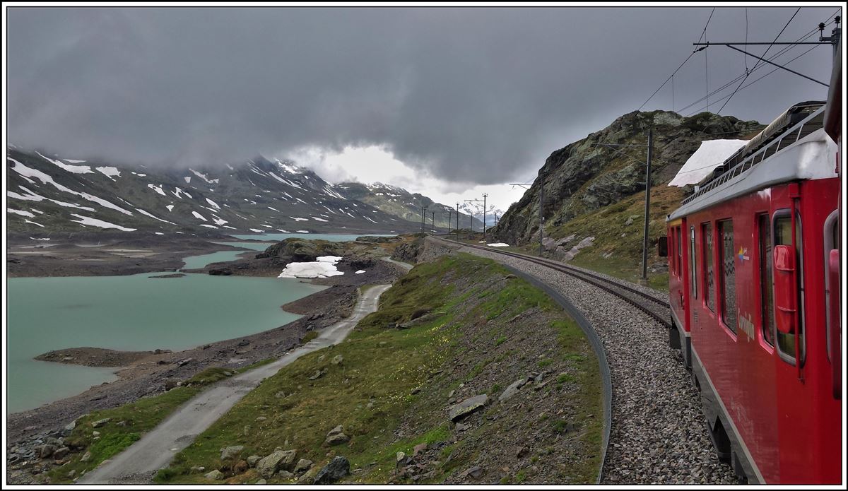 Das Wetter wechselt schnell auf dem Berninapass. R4656 mit ABe 4/4 III 56  Corviglia  und 52  Brusio  fährt dem Lago Bianco entlang Richtung Ospizio Bernina 2253m. (09.06.2020)