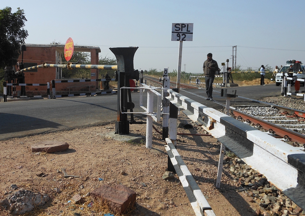Davon unbeeindruckt, dass die Schranken geschlosssen sind und ein Zug herannaht, werden die Gleise überquert. Aufnahme entstand am 22.12.2011 in der Nähe von Pokran im Bundesstaat Rajasthan.