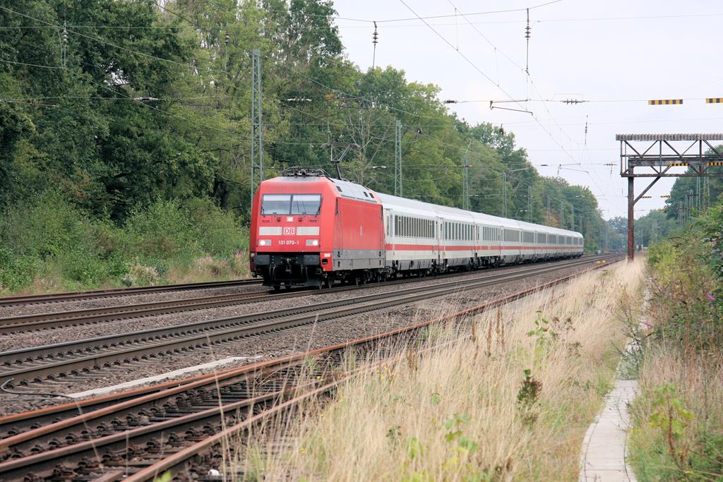 DB 101070 ist hier mit einem IC am 15.9.2018 um 10.46 Uhr auf der Rollbahn in Richtung Süden unterwegs. Gerade fährt der Zug durch den inzwischen unbesetzten Bahnhof Natrup-Hagen. Die beiden äußeren Überholgleise sind außer Funktion. Ein Ladegleis, was früher unter dem noch stehenden Brückenkran durch führte, ist längst abgebaut!