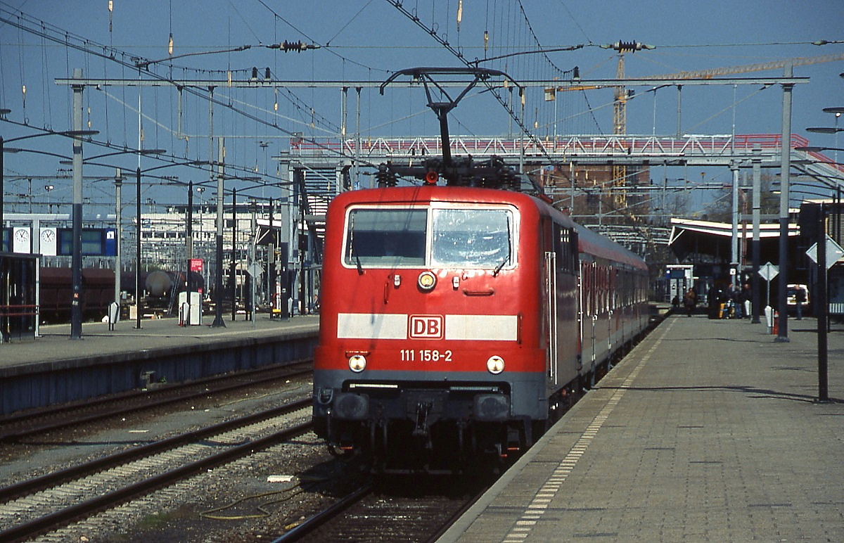 DB 111 158-2 im April 2010 im NS-Bahnhof Venlo. Dort treffen das deutsche Wechselstromsystem und das niederländische 1,5 V-Gleichstromnetz aufeinander. Die Oberleitungen einiger Gleise wie hier am Bahnsteiggleis 1 können daher umgeschaltet werden.