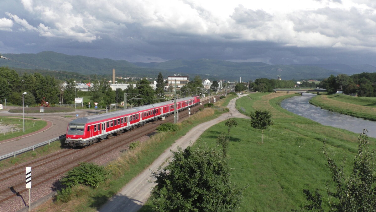 DB 111 189 schiebt am 25.07.2021 ihren Murgtäler Radexpress von Freudenstadt nach Ludwigshafen am Rhein. Hier fährt der Zug in der Abendsonne durch Bad Rotenfelds entlang der Murg.