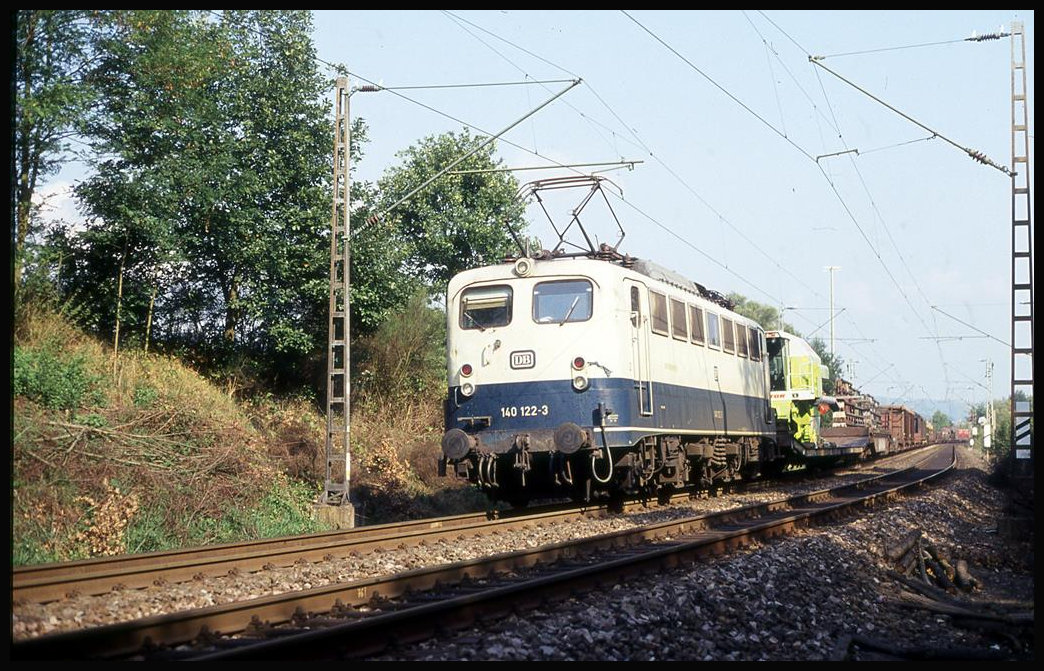 DB 140122 ist hier bei Ürzig am 29.9.1993 um 12.55 Uhr mit einem Güterzug in Richtung Trier unterwegs. Zur Ladung gehört auch ein Claas Mähdrescher.